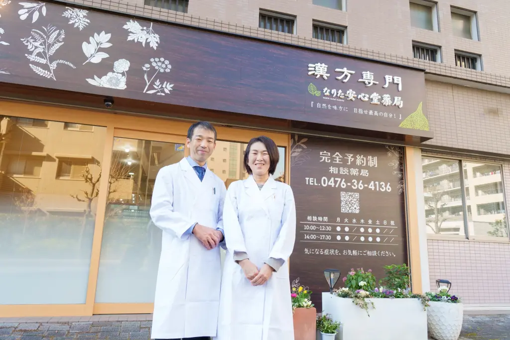 漢方専門なりた安心堂薬局の外で撮影したスタッフプロフィール写真